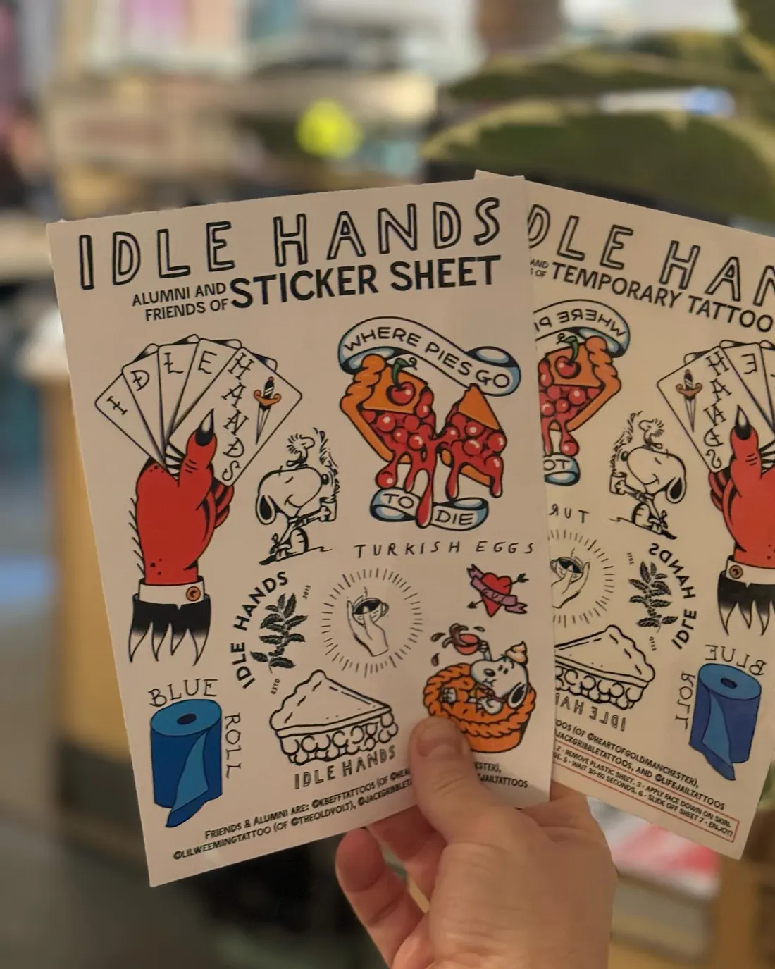 Retail shelf at Idle Hands with mugs, tees and tote bags